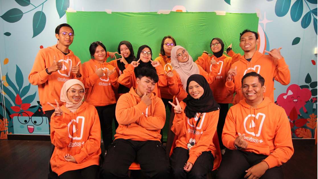 The Durioo+ team wearing orange branded hoodies
